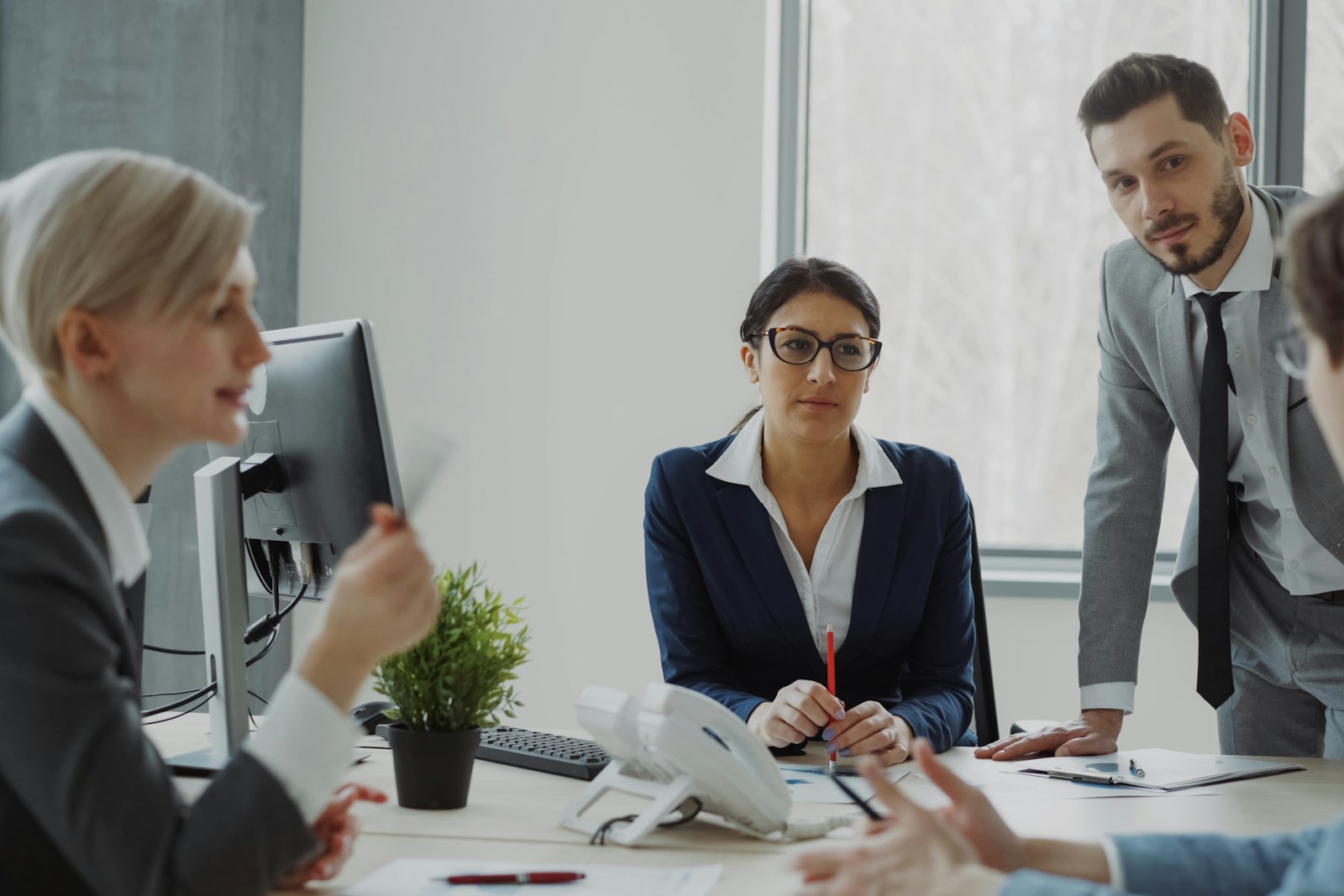 Colleagues discussing a plan around a meeting table in a bright modern office